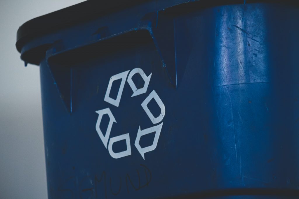 A blue bin with a recycling logo on it